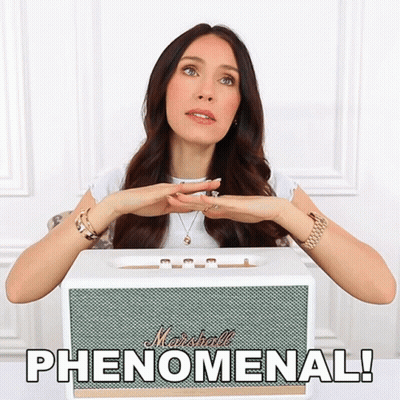 A Woman Sitting In Front Of A White Marshall Speaker GIF