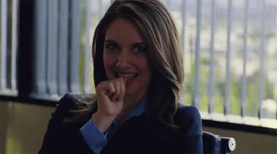 A Woman Sitting In Front Of A Window With Her Hand On Her Mouth GIF
