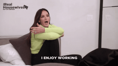 A Woman Sitting On A Bed With A Real Housewives Logo In The Background GIF