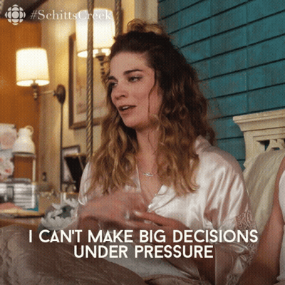 A Woman Sitting On A Bed With The Words I Can T Make Big Decisions Under Pressure GIF