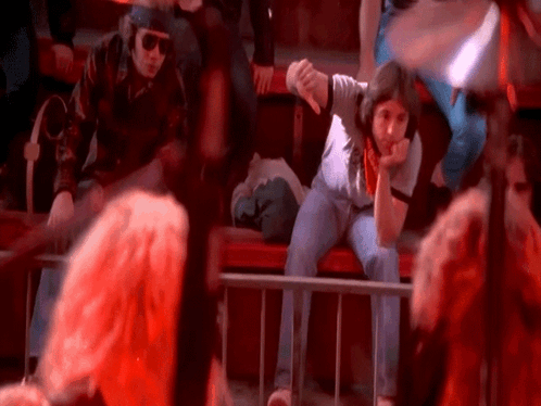 A Woman Sitting On A Bench Giving The Thumbs Down Sign GIF