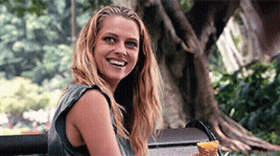 A Woman Sitting On A Bench Holding An Ice Cream Cone GIF