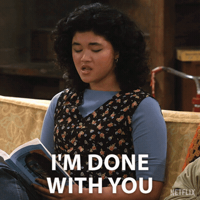 A Woman Sitting On A Couch Reading A Book With The Words I 'M Done With You Below Her GIF