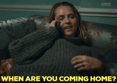 A Woman Sitting On A Couch Talking On A Cell Phone With The Words " When Are You Coming Home " Written In Yellow GIF