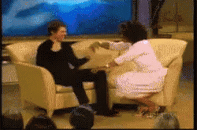 A Woman Sitting On A Couch Talking To A Man GIF