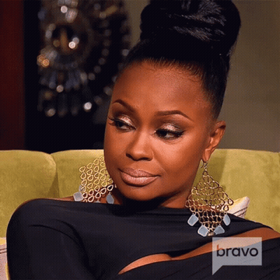 A Woman Sitting On A Couch With A Bravo Logo On The Corner Of Her Shirt GIF
