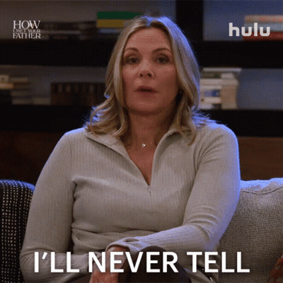 A Woman Sitting On A Couch With A Hulu Logo Behind Her GIF