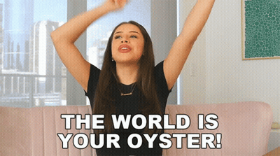 A Woman Sitting On A Couch With Her Arms Outstretched And The Words " The World Is Your Oyster " Above Her GIF