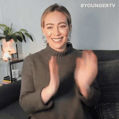 A Woman Sitting On A Couch With Her Hands In The Air And The Hashtag Youngertv GIF