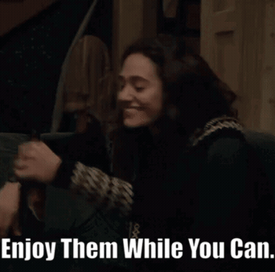 A Woman Sitting On A Couch With The Words Enjoy Them While You Can Written Below Her GIF