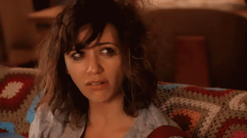 A Woman Sitting On A Couch With The Words Hot Mess Written In Yellow Letters GIF