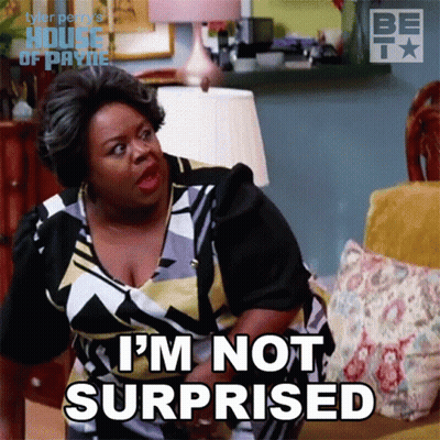 A Woman Sitting On A Couch With The Words I 'M Not Surprised On Her Face GIF