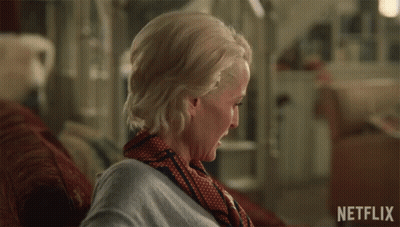 A Woman Sitting On A Couch With The Words I 'M Sorry Written On The Bottom GIF