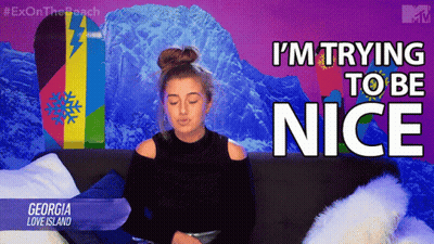 A Woman Sitting On A Couch With The Words I 'M Trying To Be Nice GIF