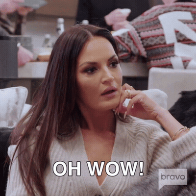 A Woman Sitting On A Couch With The Words Oh Wow Written On Her Face GIF