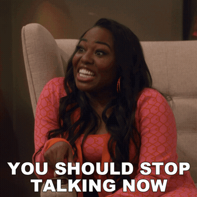 A Woman Sitting On A Couch With The Words " You Should Stop Talking Now " Written Below Her GIF