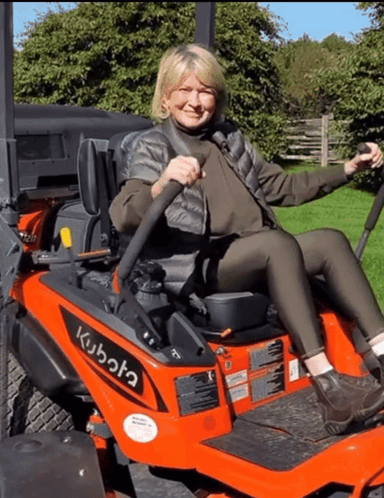 A Woman Sitting On A Kubota Lawn Mower GIF