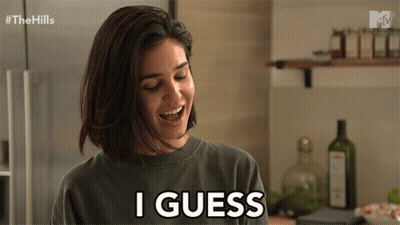 A Woman Smiles And Says I Guess In A Kitchen GIF