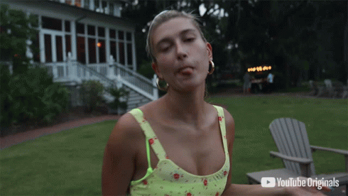 A Woman Smoking A Cigarette In Front Of A Youtube Originals Advertisement GIF