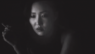 A Woman Smoking A Cigarette With A Tattoo On Her Arm That Says I Love You GIF