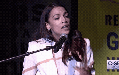 A Woman Speaking Into A Microphone In Front Of A Sign That Says C-Sf 40Y GIF