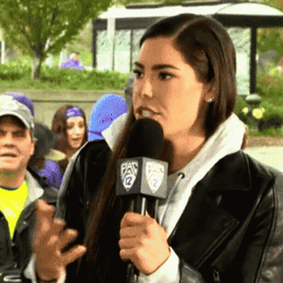 A Woman Speaking Into A Microphone With The Number 12 On The Side GIF
