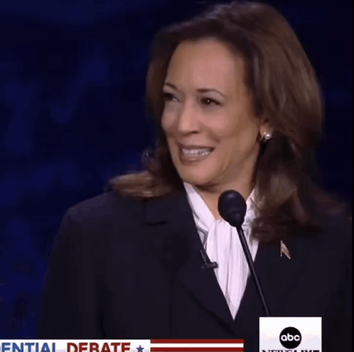 A Woman Speaking Into A Microphone With The Words Initial Debate On The Bottom GIF