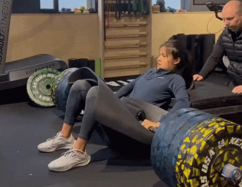 A Woman Squatting On A Barbell That Says Us Army GIF