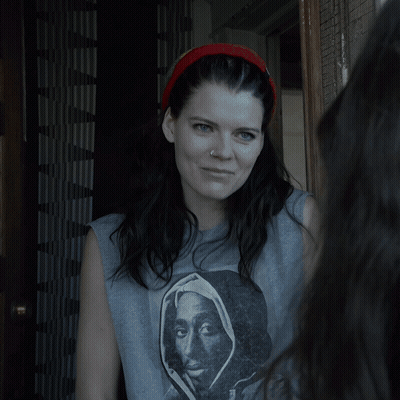 A Woman Standing In A Doorway With A Headband On GIF