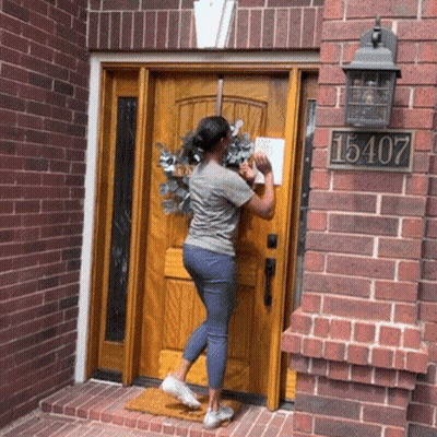 A Woman Standing In Front Of A Door With The Number 15407 GIF