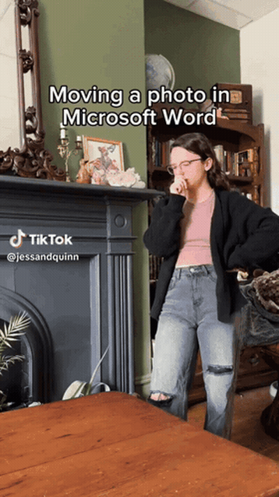 A Woman Standing In Front Of A Fireplace With The Caption Moving A Photo In Microsoft Word On It GIF