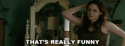 A Woman Standing In Front Of A Mirror With The Words That 'S Really Funny Written Below Her GIF