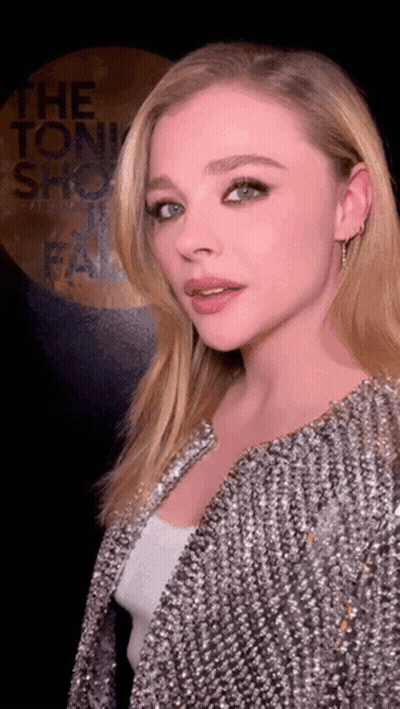 A Woman Standing In Front Of A Sign That Says The Tonight Show Fail GIF