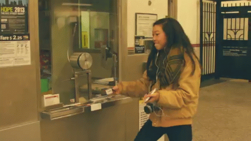 A Woman Standing In Front Of A Ticket Booth With A Poster That Says Hope 2013 GIF