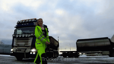 A Woman Standing In Front Of A Truck That Says Trucker Cassie On The Bottom GIF