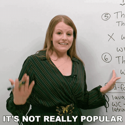 A Woman Standing In Front Of A White Board With The Words " It 'S Not Really Popular " On The Bottom GIF