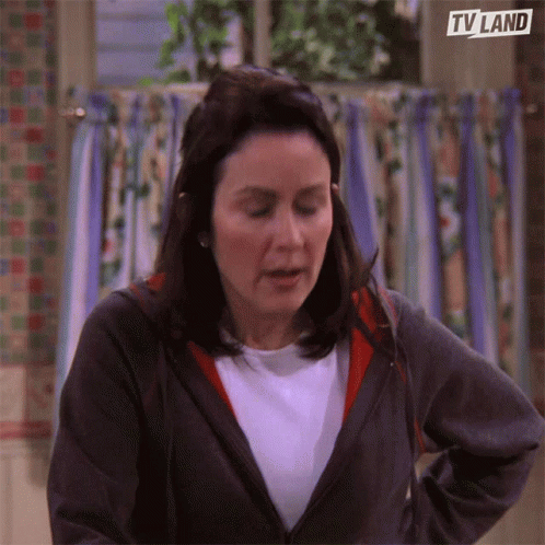 A Woman Standing In Front Of A Window With A Tv Land Logo On The Bottom Right GIF
