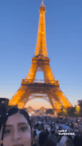 A Woman Standing In Front Of The Eiffel Tower With The Words I Am A Superstar Below Her GIF