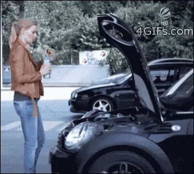 A Woman Standing Next To A Black Car With The Hood Up GIF