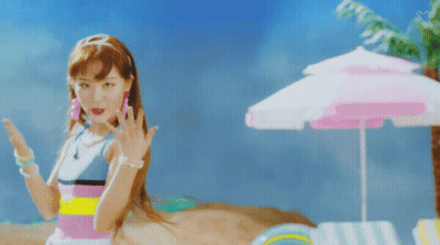 A Woman Standing On A Beach With A Pink Umbrella In The Background GIF