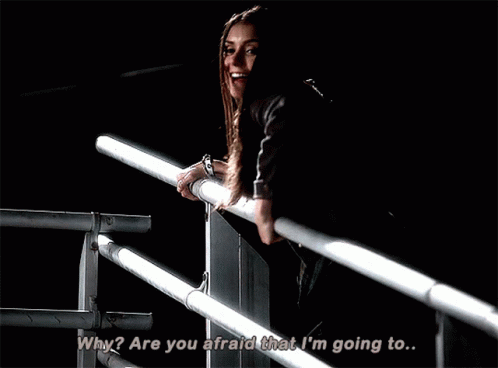A Woman Standing On A Railing With The Words " Why Are You Afraid That I 'M Going To " GIF