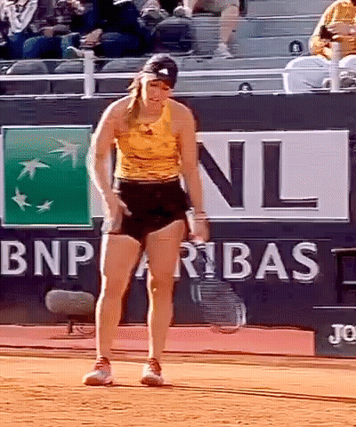 A Woman Standing On A Tennis Court In Front Of A Bnp Paribas Sign GIF