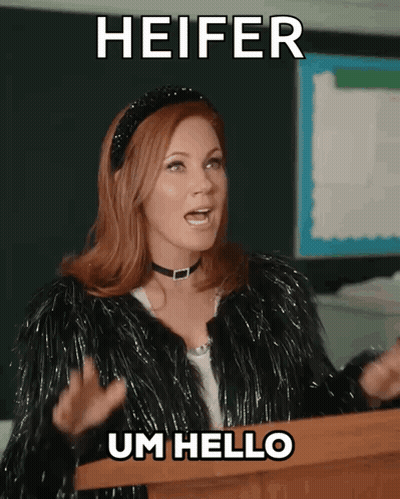 A Woman Stands At A Podium With The Words Heifer Um Hello Below Her GIF