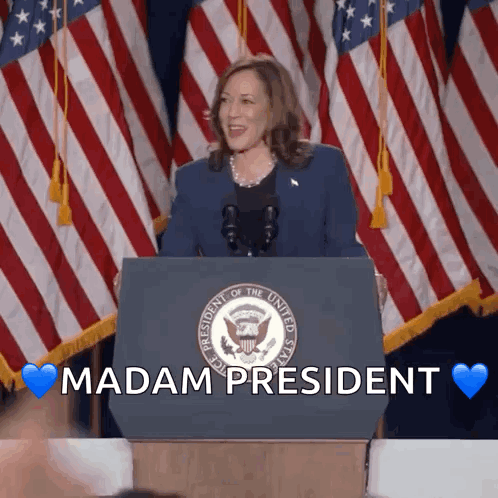 A Woman Stands Behind A Podium With The Words " Madam President " Written On It GIF