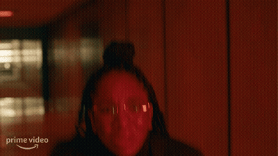 A Woman Stands In A Dark Hallway With Her Hands Up And A Prime Video Logo In The Corner GIF