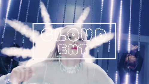 A Woman Stands In Front Of A Banner That Says Cloud Ent GIF