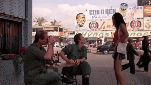 A Woman Stands In Front Of A Billboard That Says Cono Ben GIF