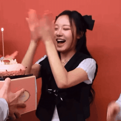 A Woman Stands In Front Of A Birthday Cake With A Candle GIF