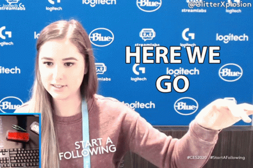 A Woman Stands In Front Of A Blue Backdrop That Says Logitech GIF