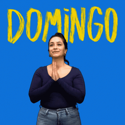 A Woman Stands In Front Of A Blue Background With The Word Domingo Written In Yellow GIF